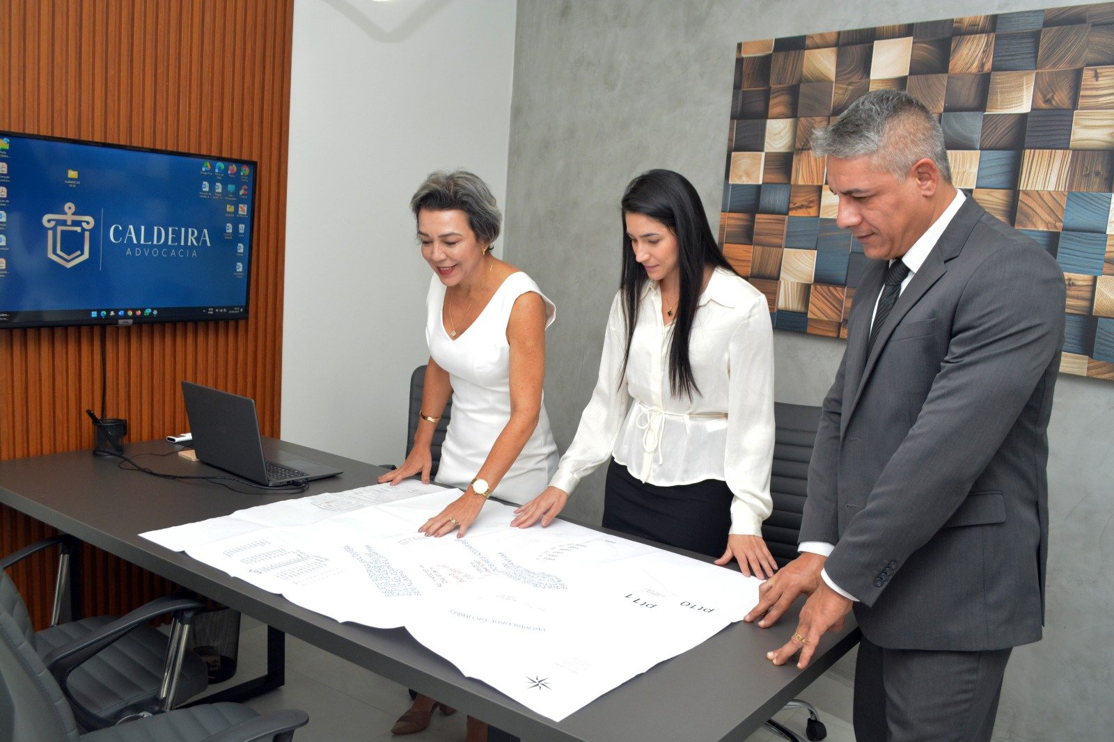 Equipe analisando planta e documentação de imóvel