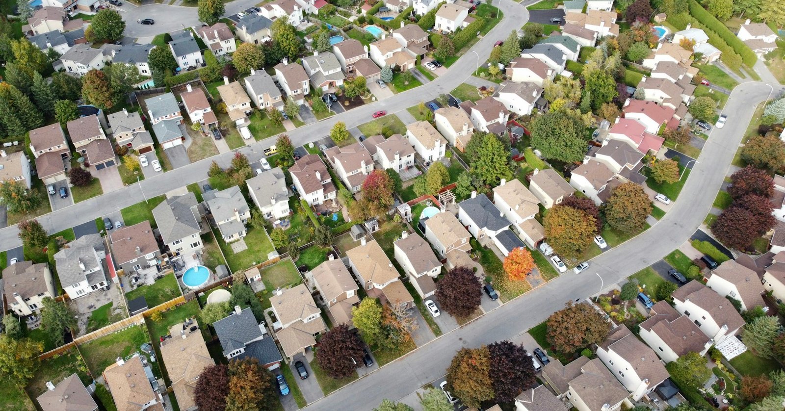 Vista aérea de bairro residencial com lotes, ruas e árvores (foto: Sophie N, Unsplash)