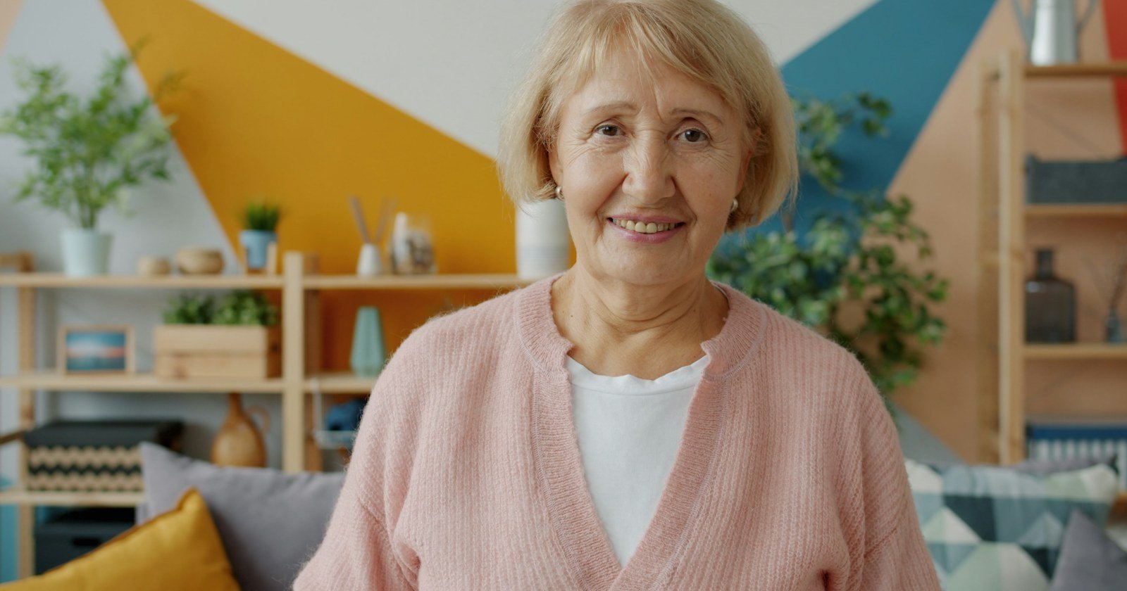 Senhora idosa sorridente na sala de casa, ilustrando o direito real de habitação do cônjuge sobrevivente