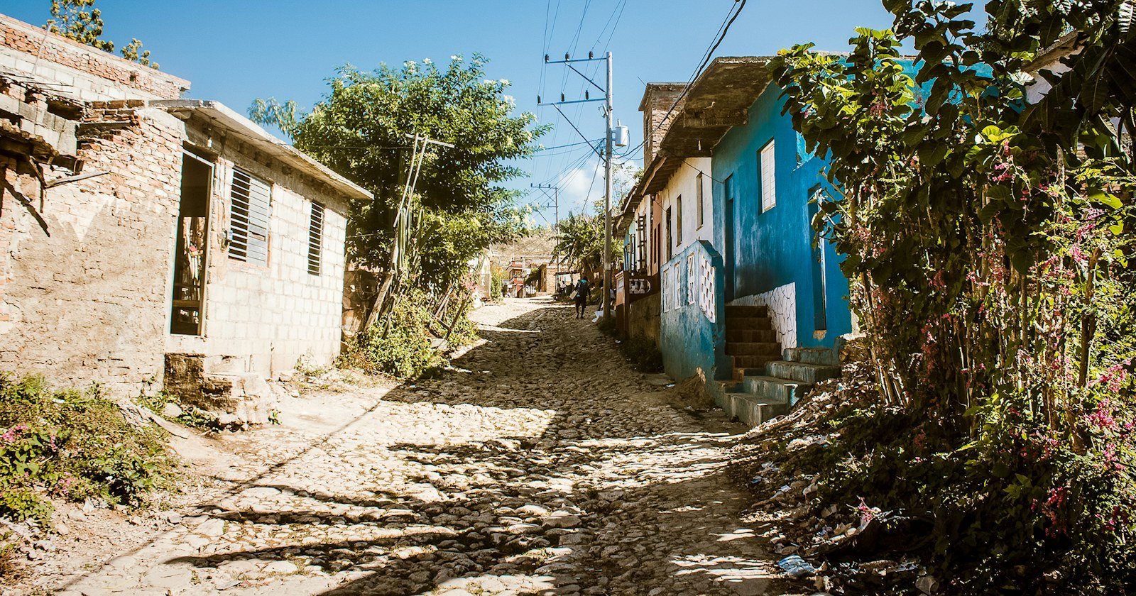 Casas simples lado a lado em uma rua de terra, ilustrando a regularização de duas casas no mesmo terreno
