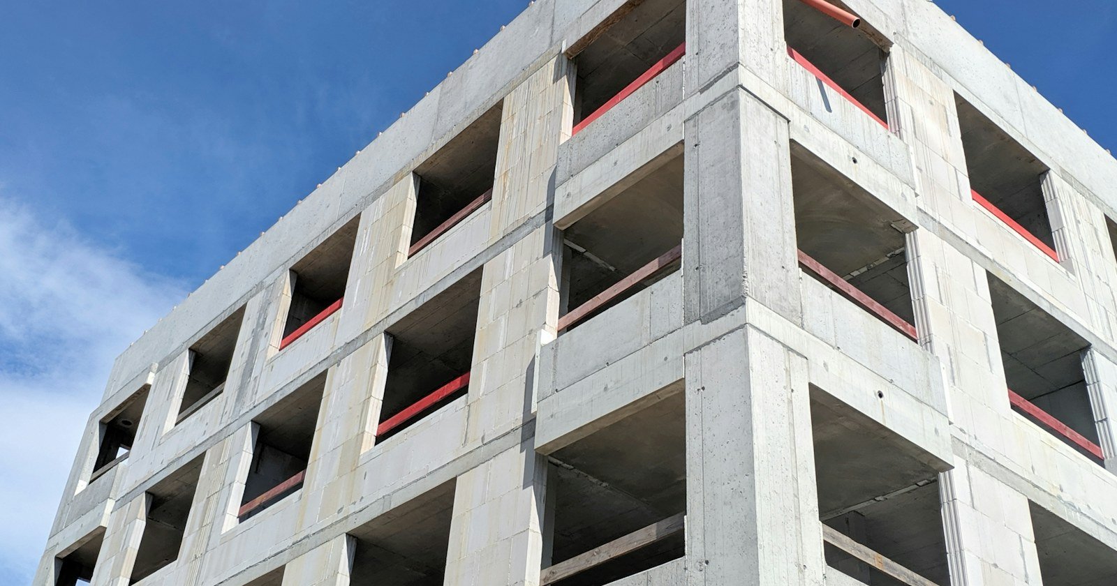 Estrutura de concreto de um prédio inacabado sob céu azul