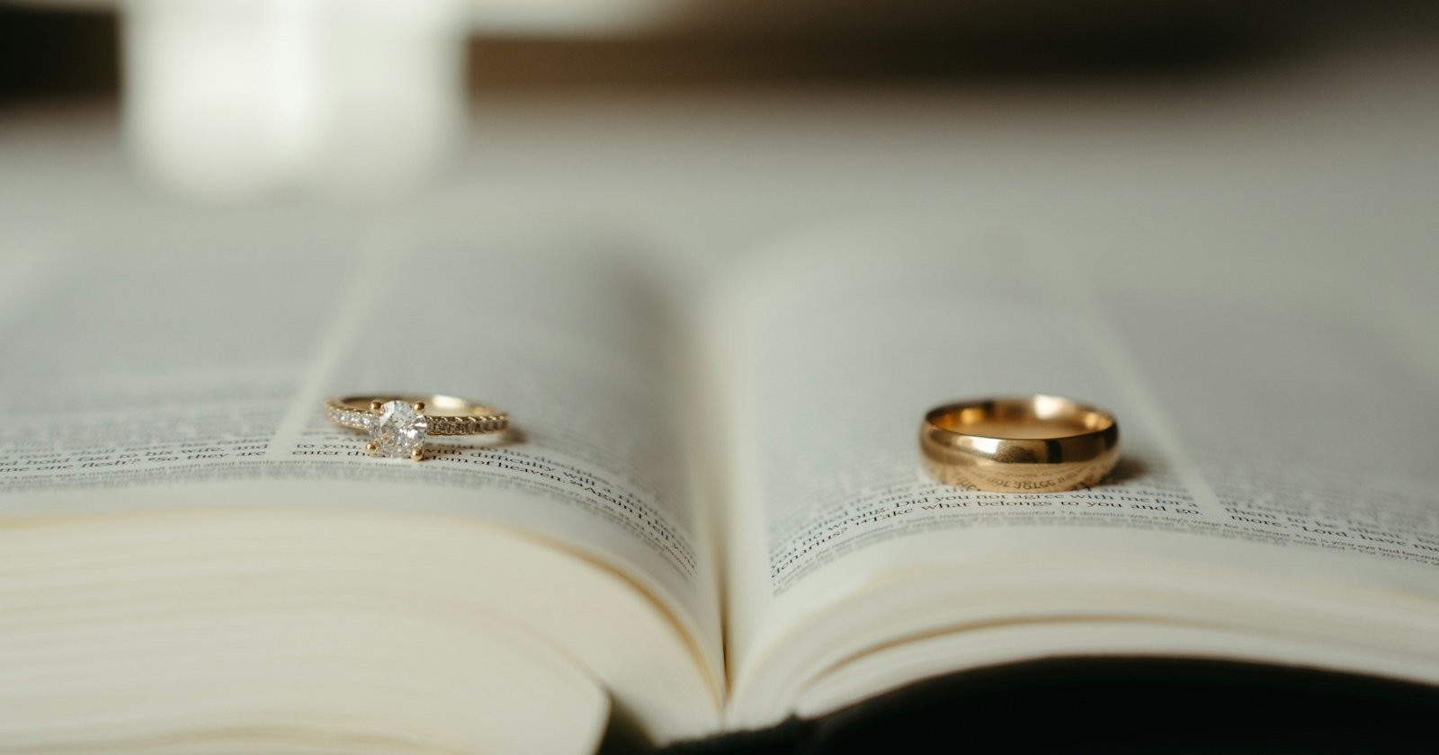 Duas alianças de casamento sobre as páginas de um livro aberto