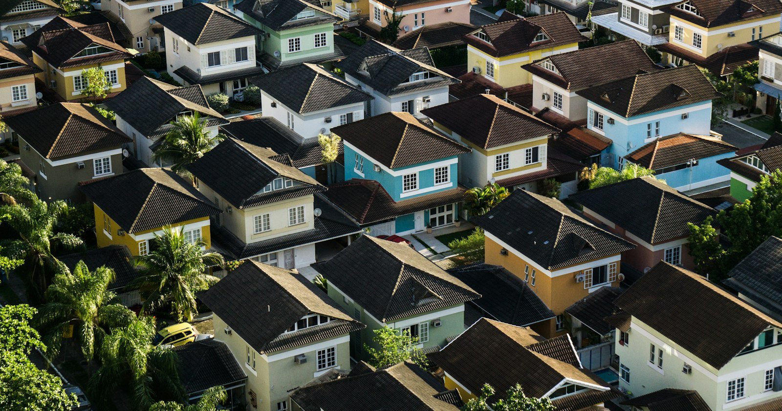 Vista aérea de bairro residencial com casas e ruas, foto de Breno Assis no Unsplash