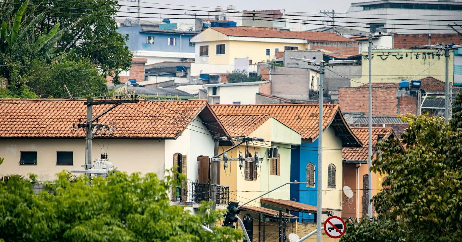 Casas de telhado colorido em bairro de encosta, ilustrando a usucapião em área urbana